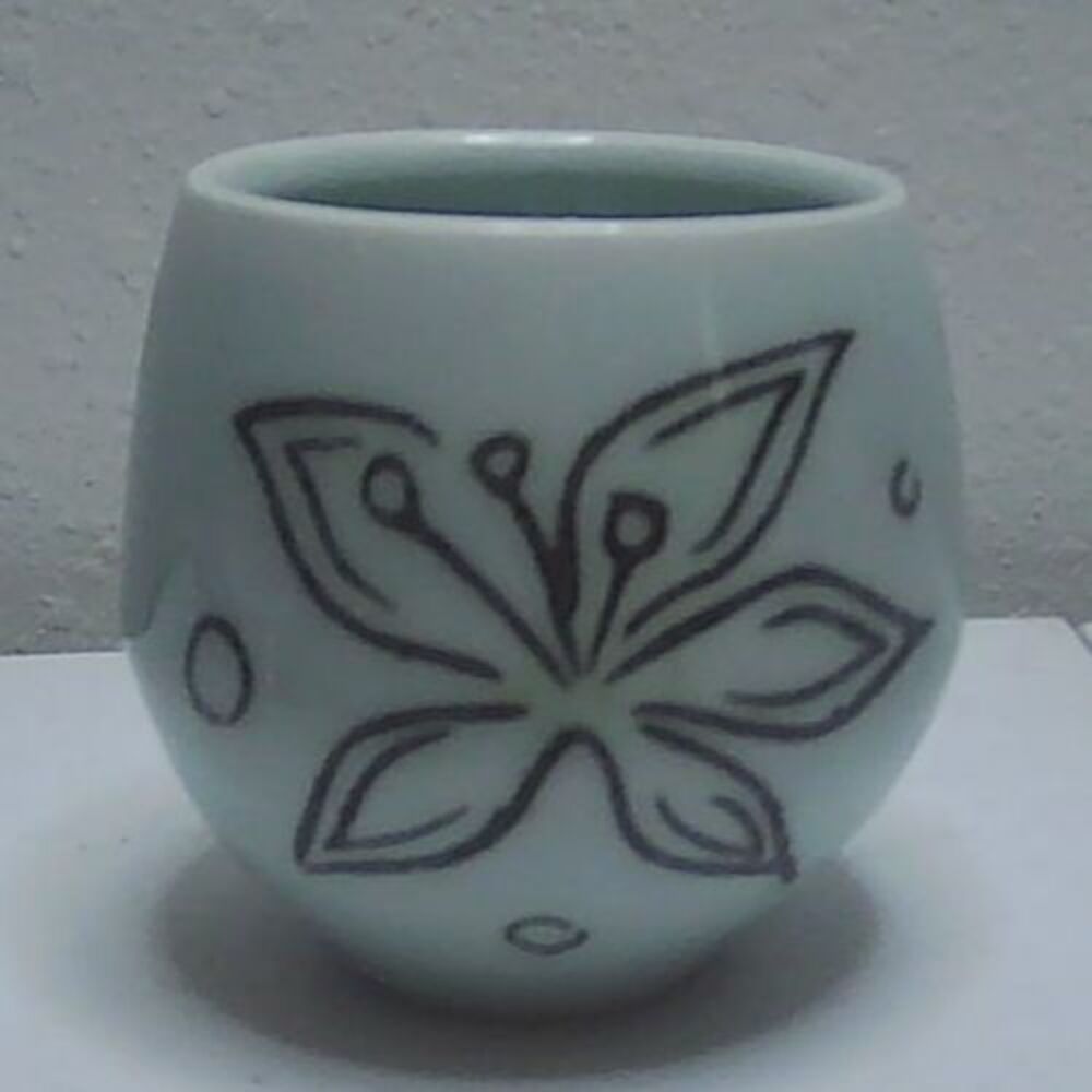 Handmade, light blue porcelain cup with florl design, signed 3" tall, 3" diam.